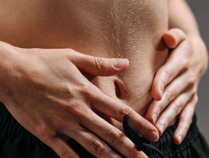 person in black pants holding womans hand