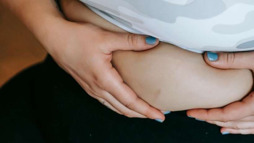 unrecognizable female in activewear touching belly