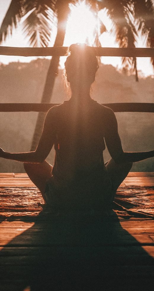 woman doing yoga meditation woman doing yoga meditation on brown parquet flooring